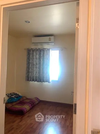 Cozy bedroom with wooden flooring and air conditioning