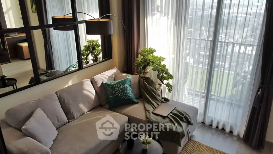 Modern living room with cozy sofa and panoramic city view through large windows.