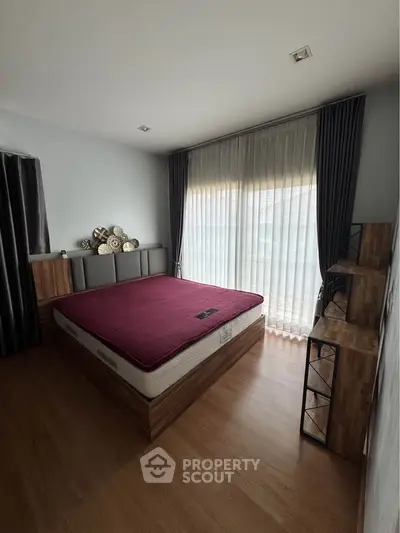 Spacious bedroom with modern decor and large window for natural light