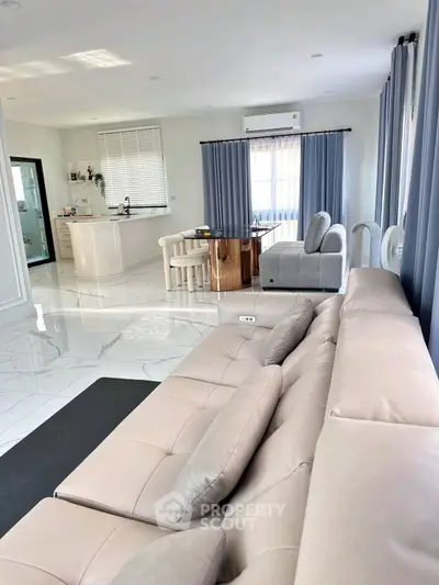 Spacious modern living room with open kitchen and elegant furnishings