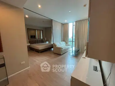 Spacious modern bedroom with elegant decor and large windows offering natural light.