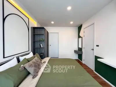 Modern bedroom with stylish decor and green accents, featuring a cozy bed and ample storage space.