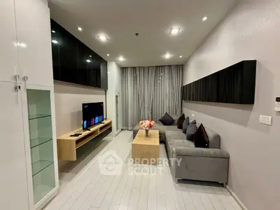 Modern living room with sleek design, featuring a cozy gray sofa, stylish TV unit, and elegant lighting.