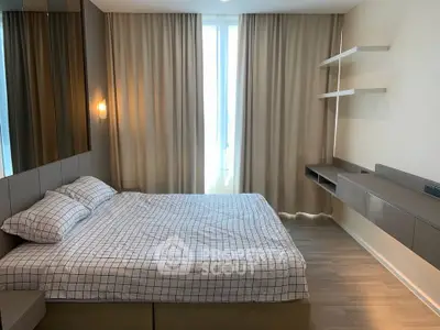 Modern bedroom with stylish decor and natural light, featuring a comfortable bed and elegant shelving.
