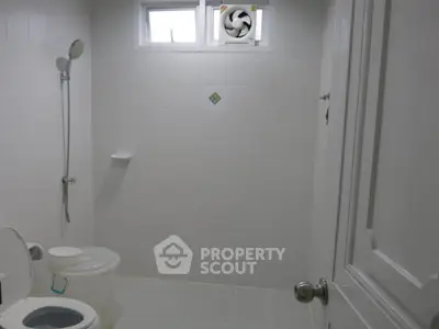 Modern minimalist bathroom with white tiles and shower area