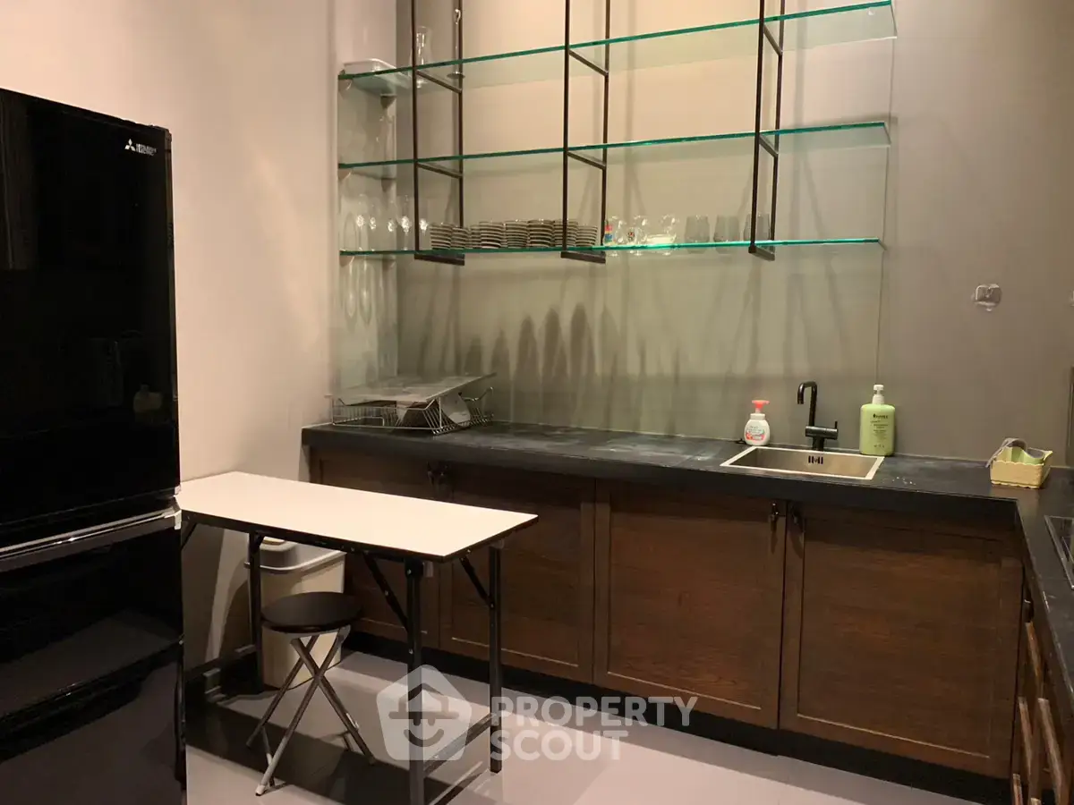 Modern kitchen with sleek black fridge and open shelving