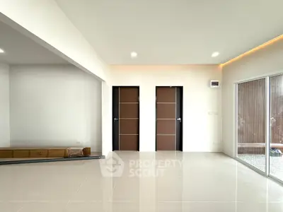 Spacious modern living room with sleek tile flooring and large windows for natural light.