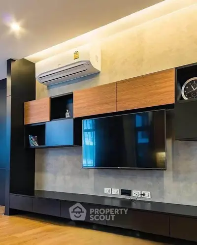 Modern living room with sleek TV unit and air conditioning, featuring stylish wooden cabinetry and ambient lighting.
