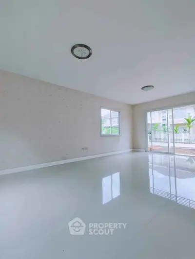 Spacious empty living room with large windows and garden view