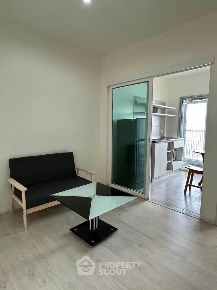 Modern living room with sleek glass table and open kitchen layout