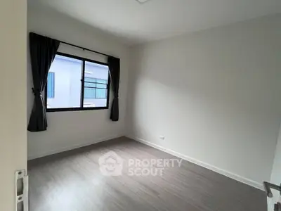 Spacious empty bedroom with large window and elegant flooring