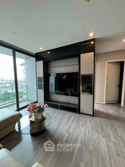 Modern living room with large windows and city view, featuring sleek TV unit and stylish decor.