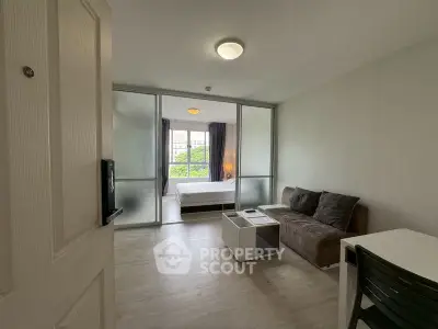 Modern studio apartment with sliding glass doors and cozy living area