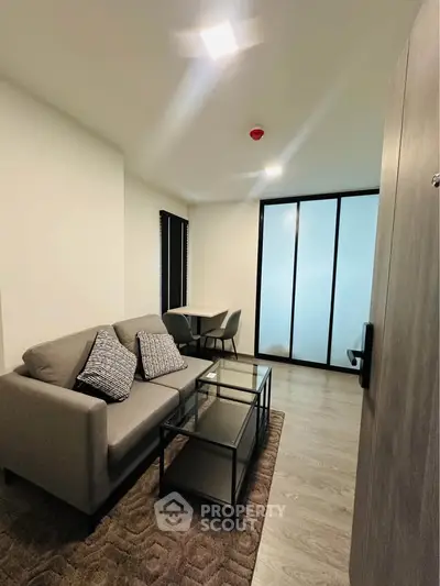 Modern living room with stylish furniture and glass partition in a cozy apartment.