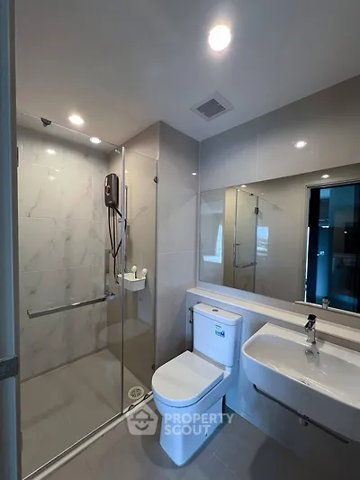 Modern bathroom with glass shower and sleek fixtures in a contemporary home.
