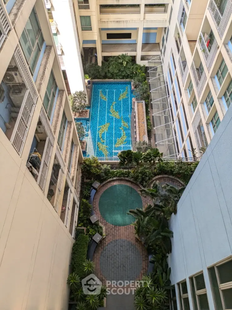 Stunning aerial view of modern apartment complex with swimming pool and lush greenery