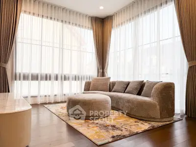 Spacious living room with elegant curved sofa and floor-to-ceiling windows