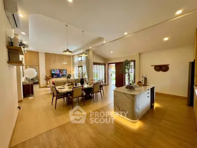 Spacious open-plan living and dining area with modern decor and natural lighting.