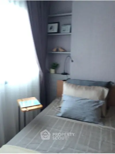 Cozy bedroom with soft lighting and modern decor, featuring a comfortable bed and stylish shelving.