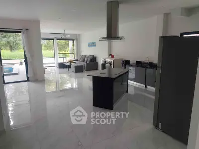 Spacious modern open-plan kitchen and living room with sleek design and large windows.