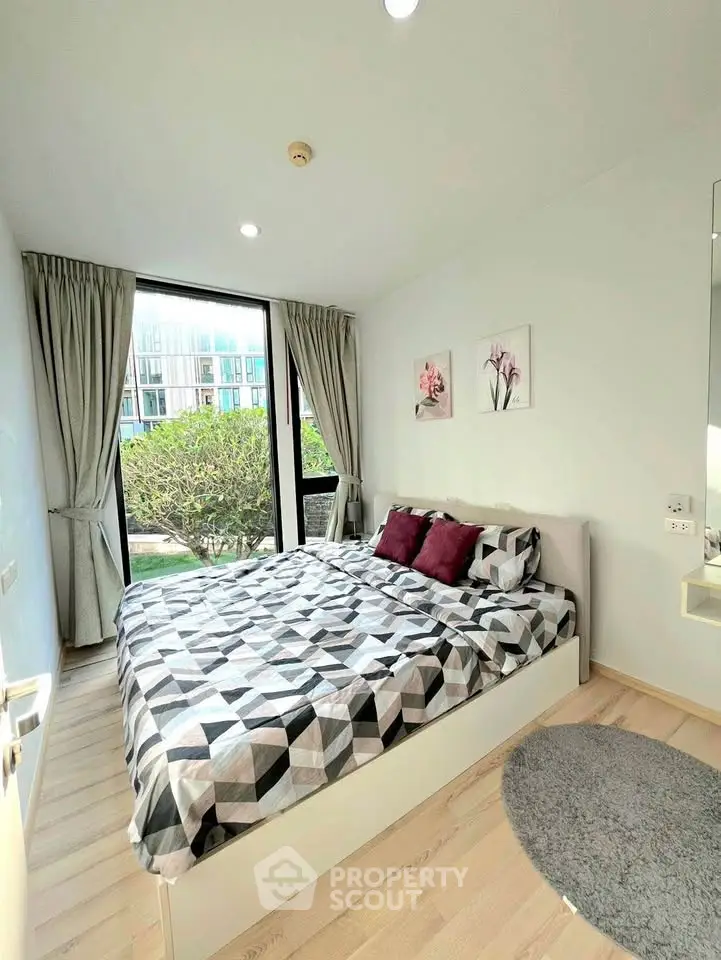 Bright and cozy bedroom with modern decor and large window view.