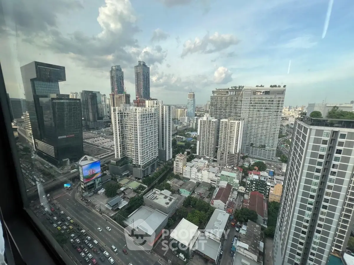 Stunning cityscape view from high-rise apartment window showcasing urban skyline and bustling streets.