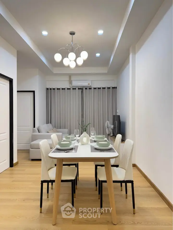 Modern dining area with elegant lighting and cozy seating in a stylish apartment.