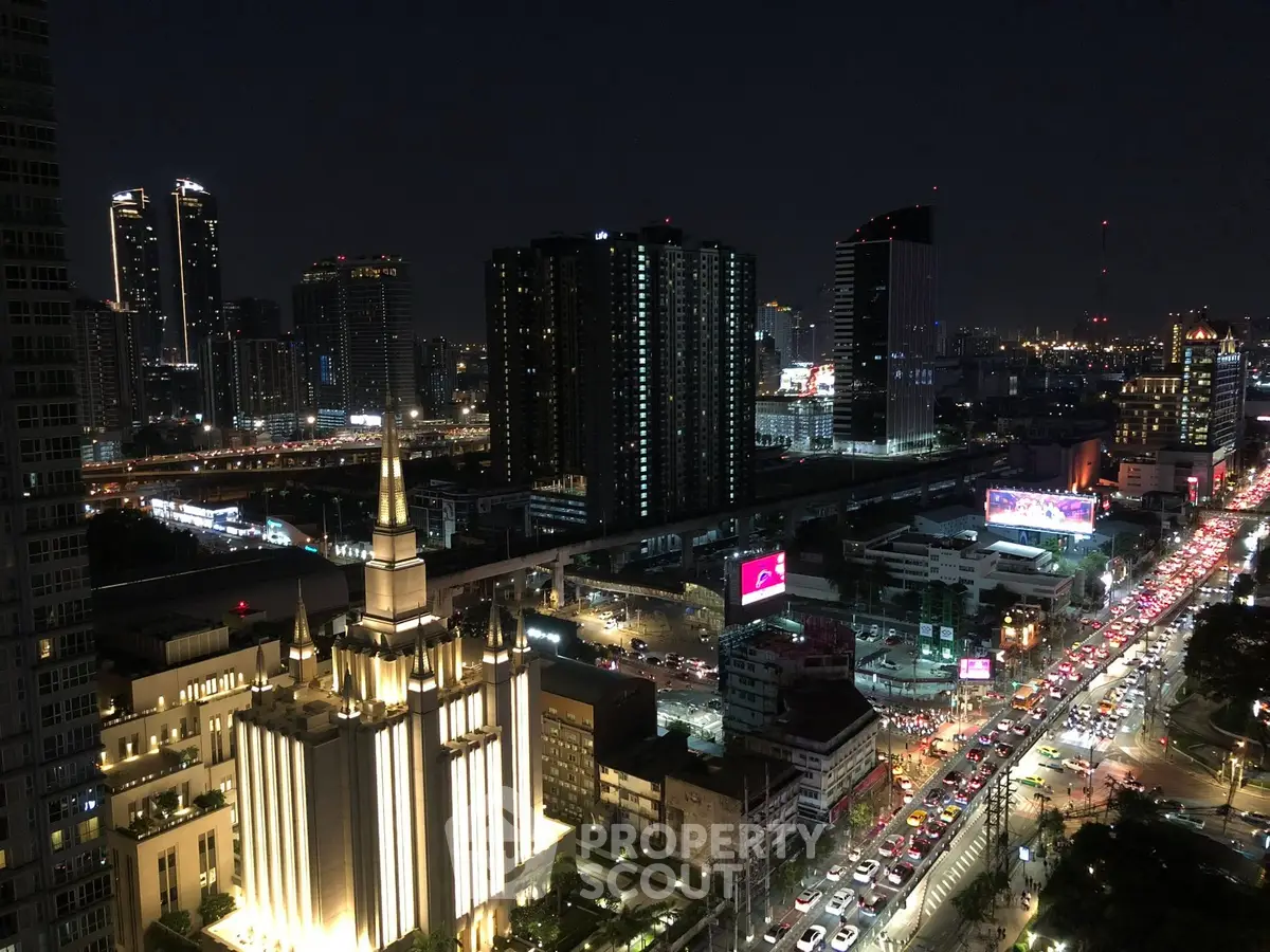 Stunning cityscape view from high-rise building at night with vibrant lights and bustling streets.