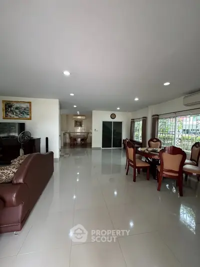Spacious open-plan living and dining area with elegant furniture and natural light.