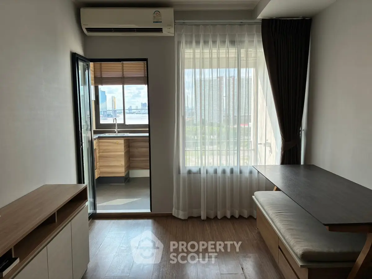 Modern living room with balcony view and stylish furniture in urban apartment.