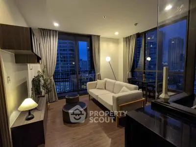 Modern living room with city view, featuring stylish furniture and floor-to-ceiling windows.