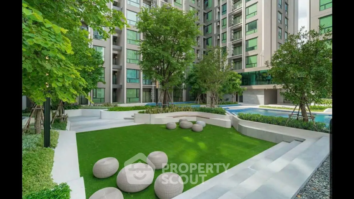 Modern apartment complex with lush garden and seating area