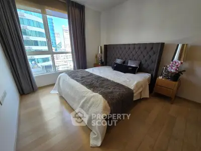 Luxurious bedroom with modern decor and stunning city view, featuring elegant furnishings and natural light.