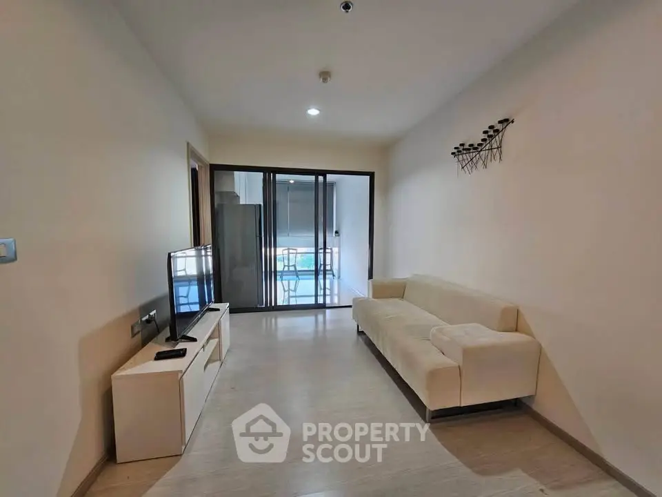 Modern living room with sleek furniture and balcony view, perfect for urban living.