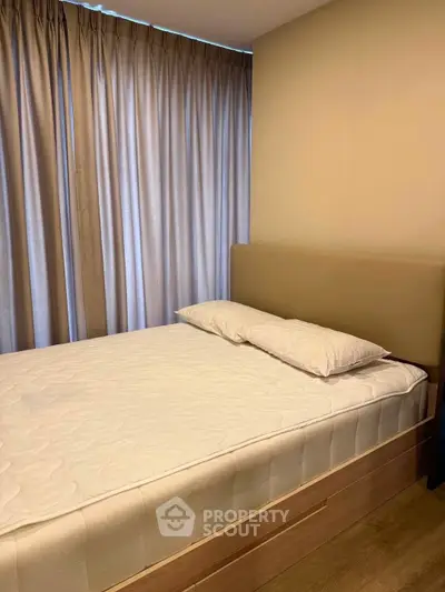 Cozy bedroom with elegant curtains and a comfortable bed in a modern apartment.