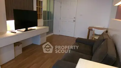 Modern living room with sleek furniture and wooden flooring in a cozy apartment.