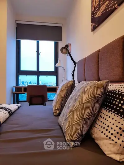 Cozy bedroom with stylish decor and city view, perfect for urban living.