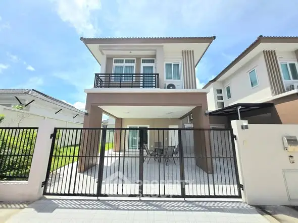 Modern two-story house with gated driveway and outdoor seating area, perfect for family living.