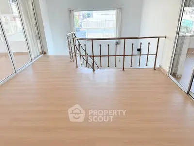 Spacious interior with elegant railing and large window offering natural light