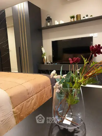 Modern bedroom with stylish decor and elegant furniture, featuring a cozy bed and sleek entertainment unit.