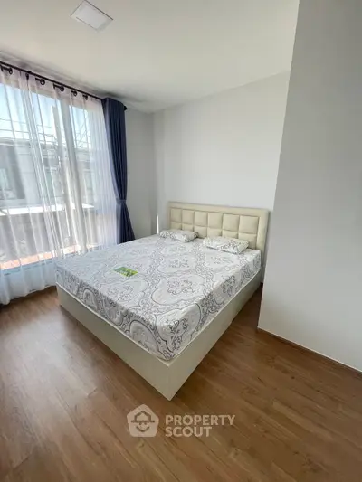 Spacious bedroom with elegant bed and large window offering natural light