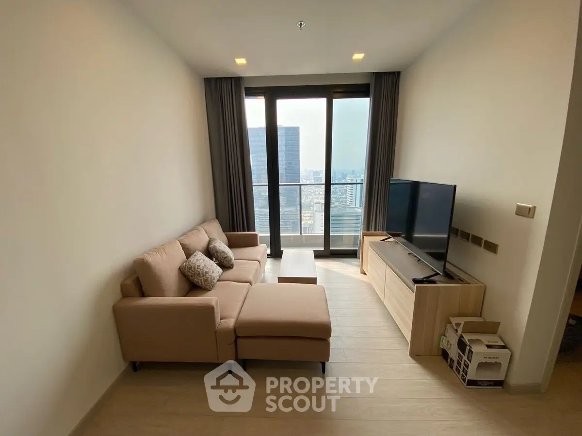 Modern living room with city view, featuring cozy sofa and large TV, perfect for urban living.