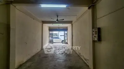 Spacious garage with concrete flooring and ceiling fan, ideal for secure parking or storage.