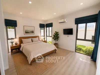 Spacious bedroom with modern decor, large windows, and natural light