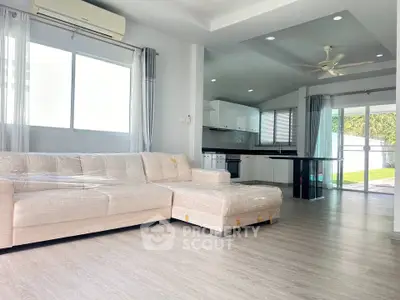 Spacious modern living room with open kitchen and large windows