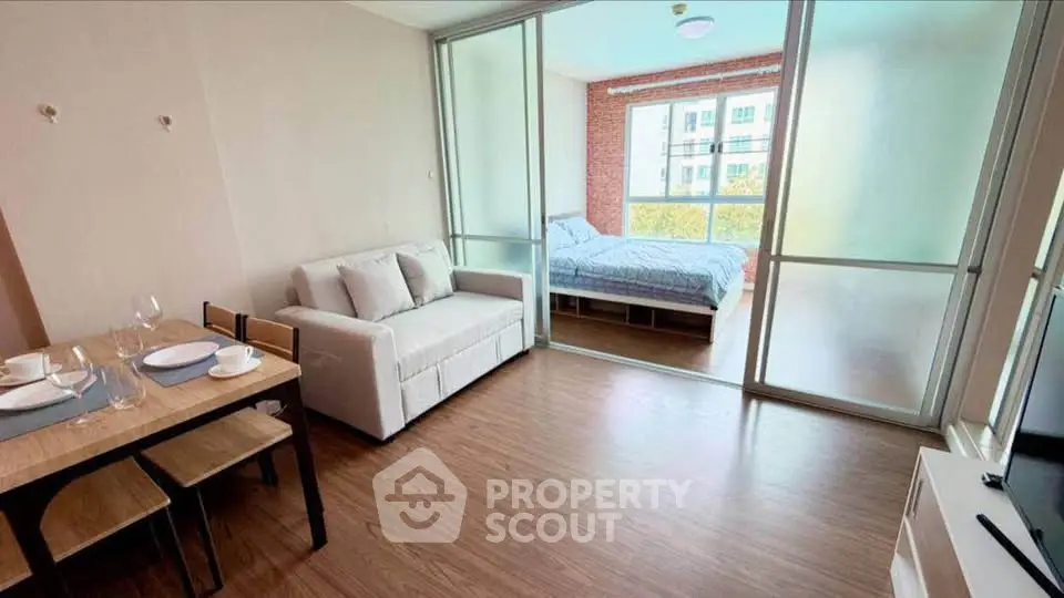 Modern studio apartment with open layout, featuring cozy living area and bedroom with large windows.