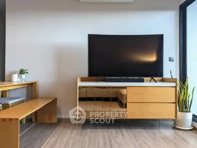 Modern living room with sleek wooden furniture and large flat-screen TV, perfect for relaxation and entertainment.