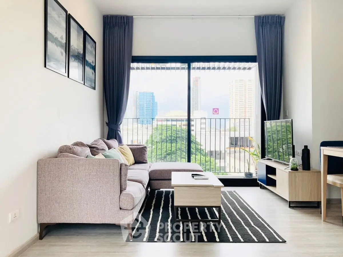 Modern living room with large window and city view, featuring stylish furniture and decor.