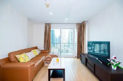 Spacious living room with modern decor and city view balcony.