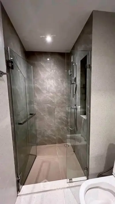 Modern bathroom with sleek glass shower enclosure and elegant tile design.